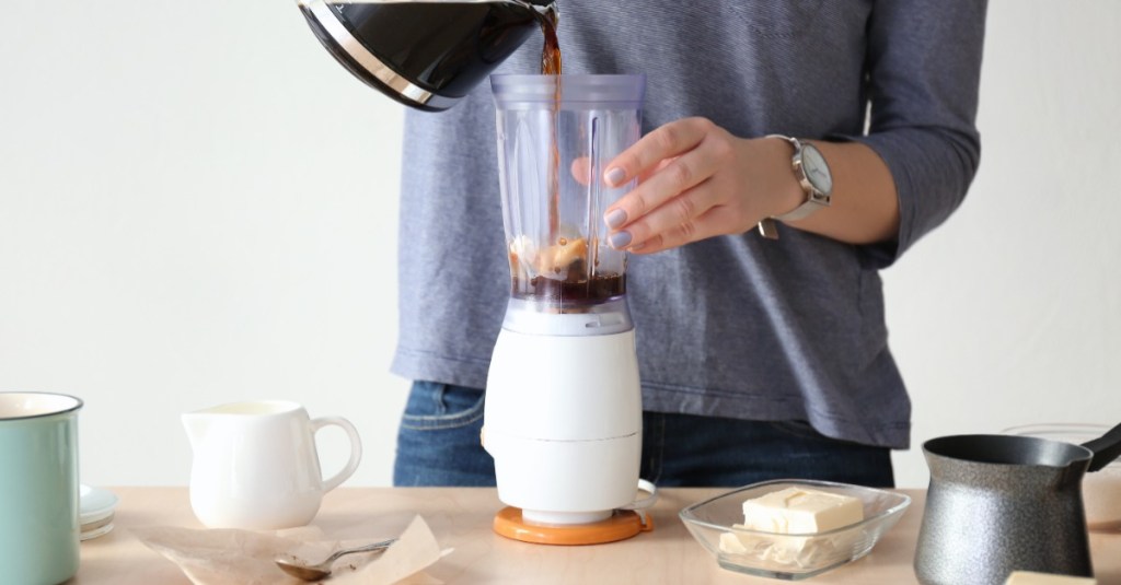 Eine Frau gibt Kaffee in einen Standmixer