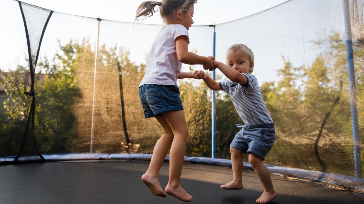 Zwei Kinder springen auf einem Trampolin