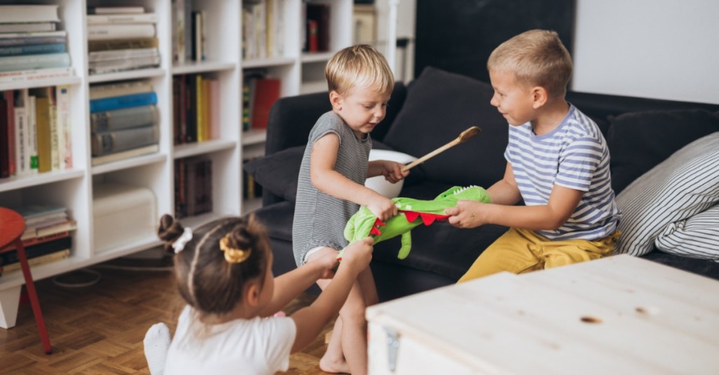 Geschwisterstreit: Drei Kinder streiten sich um ein Kuscheltier