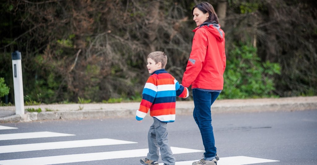 Erziehungsprobleme: Mutter und Sohn überqueren Hand in Hand eine Straße