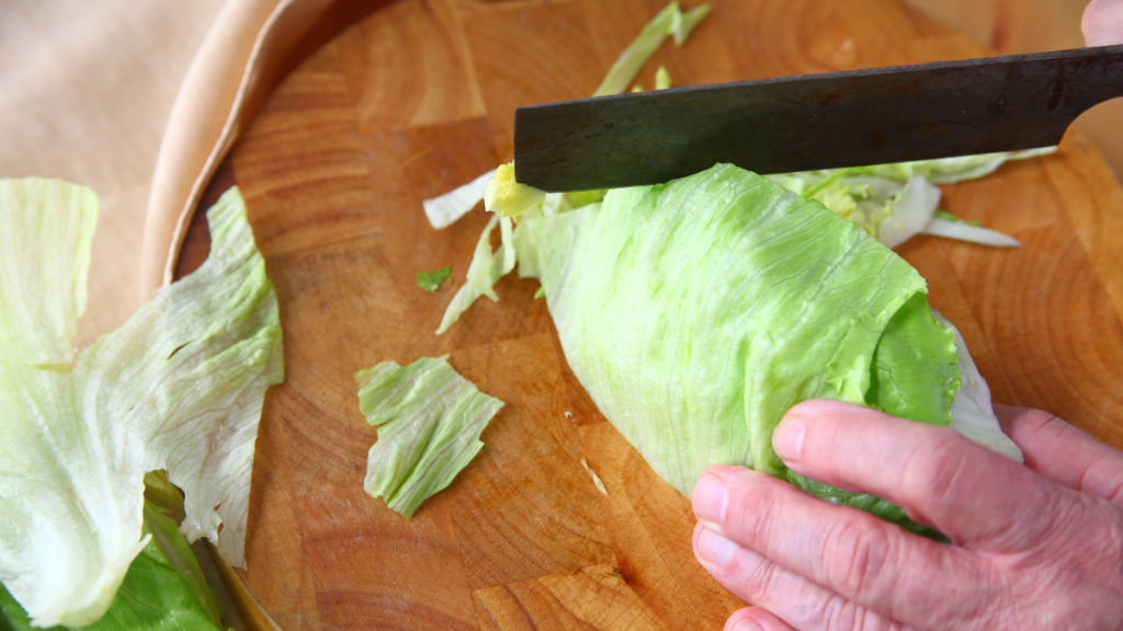 Eisbergsalat wird geschnitten