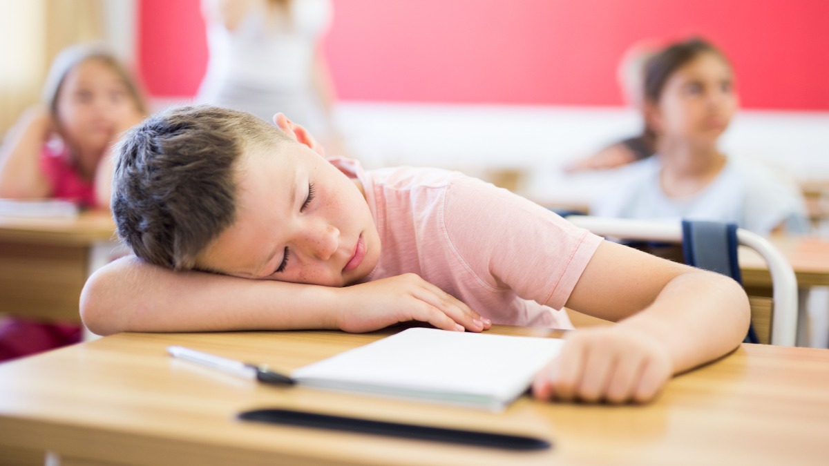 Junge schlÃ¤ft vor ErschÃ¶pfung auf dem Schultisch ein