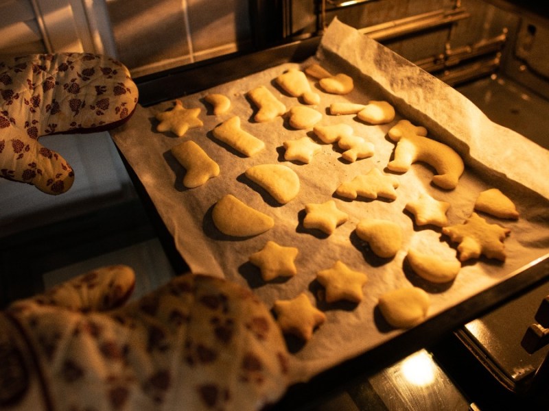 Plätzchen backen: Ein Backblech mit Plätzchen wird in den Ofen geschoben