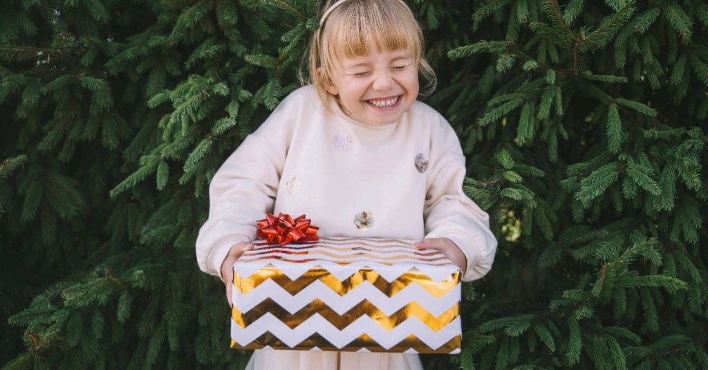 Geschenke Kinder: Mädchen freut sich über ein Geschenk