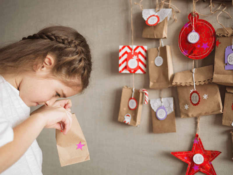 MÃ¤dchen schaut in ein AdventskalendertÃ¼rchen