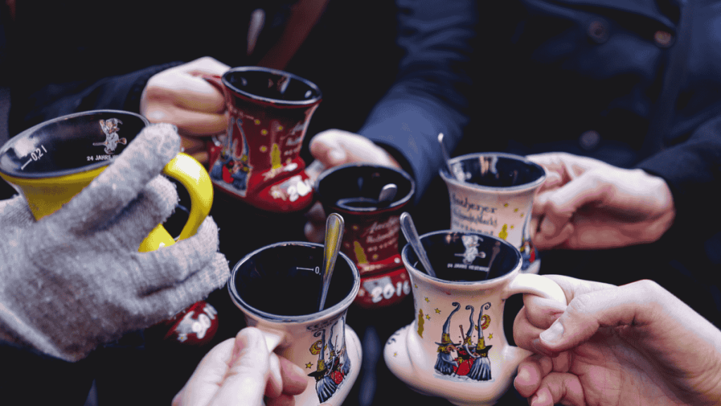 Weihnachtsmarkt, Leute stoßen mit Punsch an.