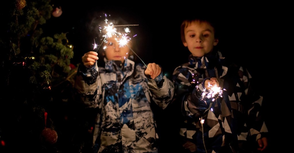 Silvester mit Kind: zwei kleine Kinder halten Wunderkerzen in den Händen