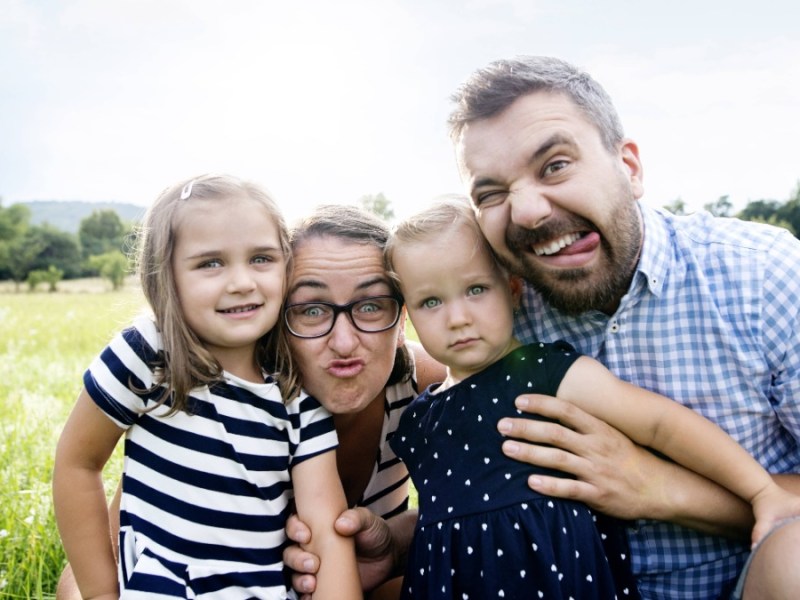 kreative Familienfotos: Vater, Mutter und zwei Kinder ziehen Grimassen fÃ¼r die Kamera