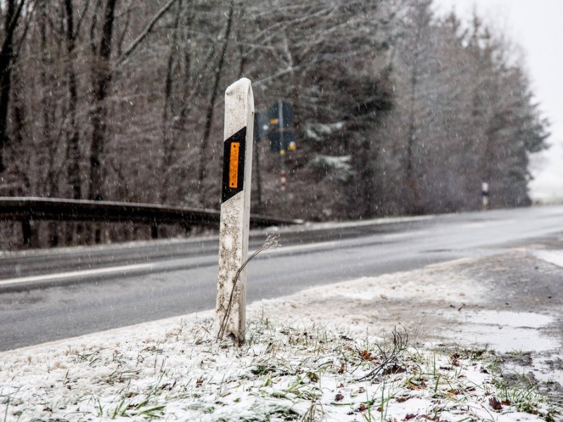 Leitpfosten am rechten Straßenrand im Winter.