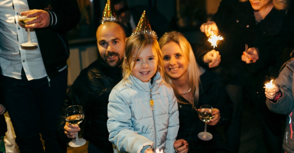 Neujahrsvorsätze: Eltern sind mit ihrer Tochter auf einer Silvesterparty