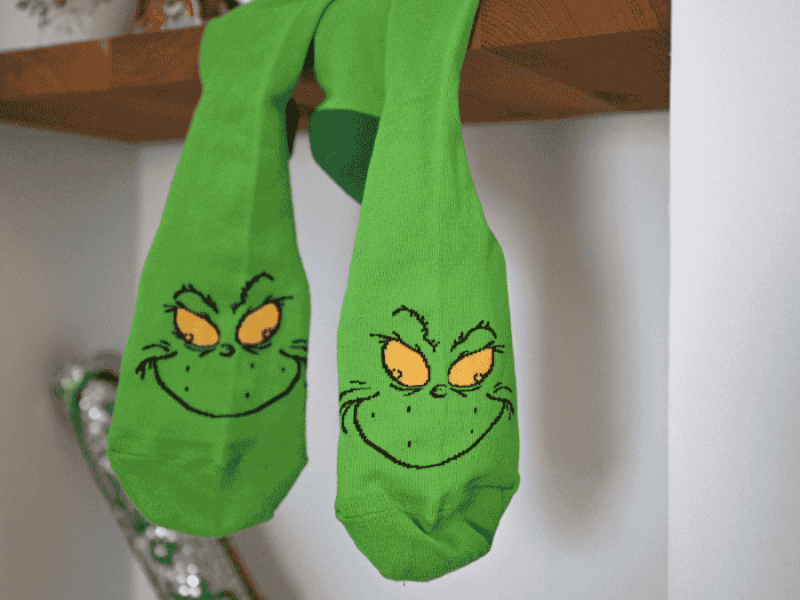 Weihnachtsmuffel, grÃ¼ne Grinch-Socken hÃ¤ngen vom Regal