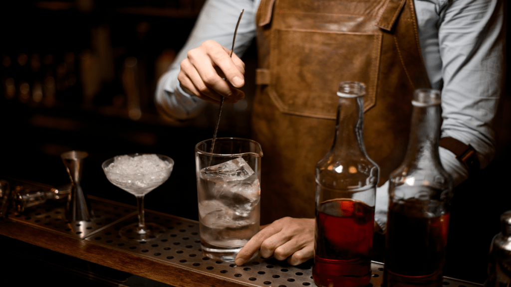 Ein Barkeeper macht einen Drink mit Alkohol ohne Label. 