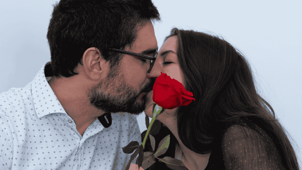Valentinstag-Ideen, küssendes Paar mit roter Rose
