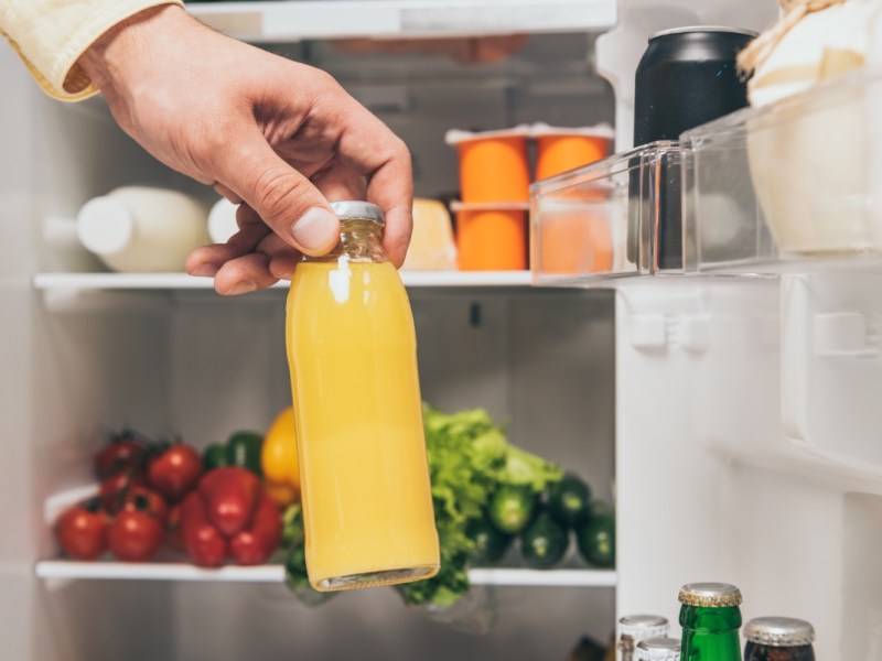 Eine Flasche Saft wird zum Einfrieren in einen Kühlschrank gegeben.