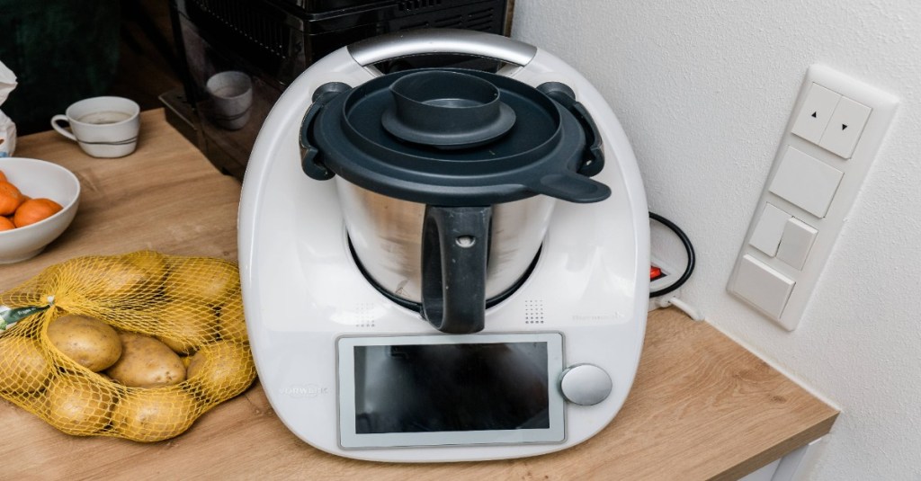 Ein Thermomix neben einem Sack Kartoffeln.
