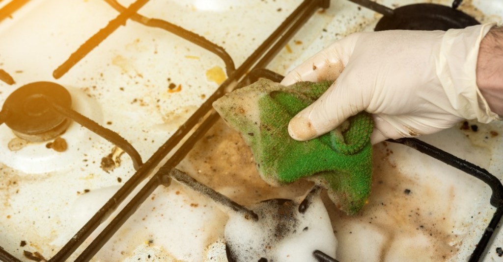 Gasherd reinigen mit einem Schwamm