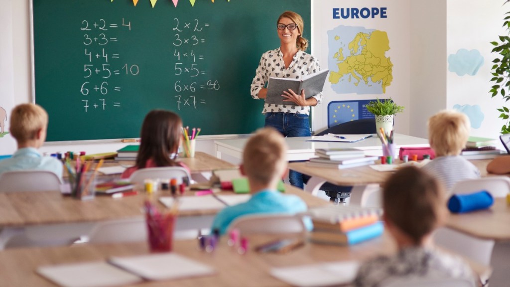 Eine Lehrerin, die vor einer Klasse steht.