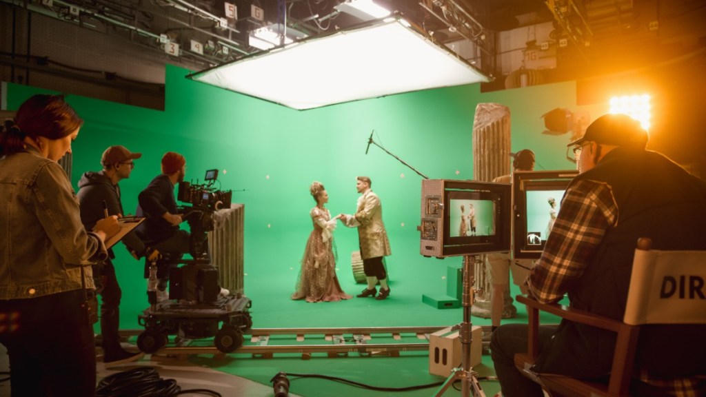Ein Filmset mit einem Greenscreen und zwei Schauspielern.